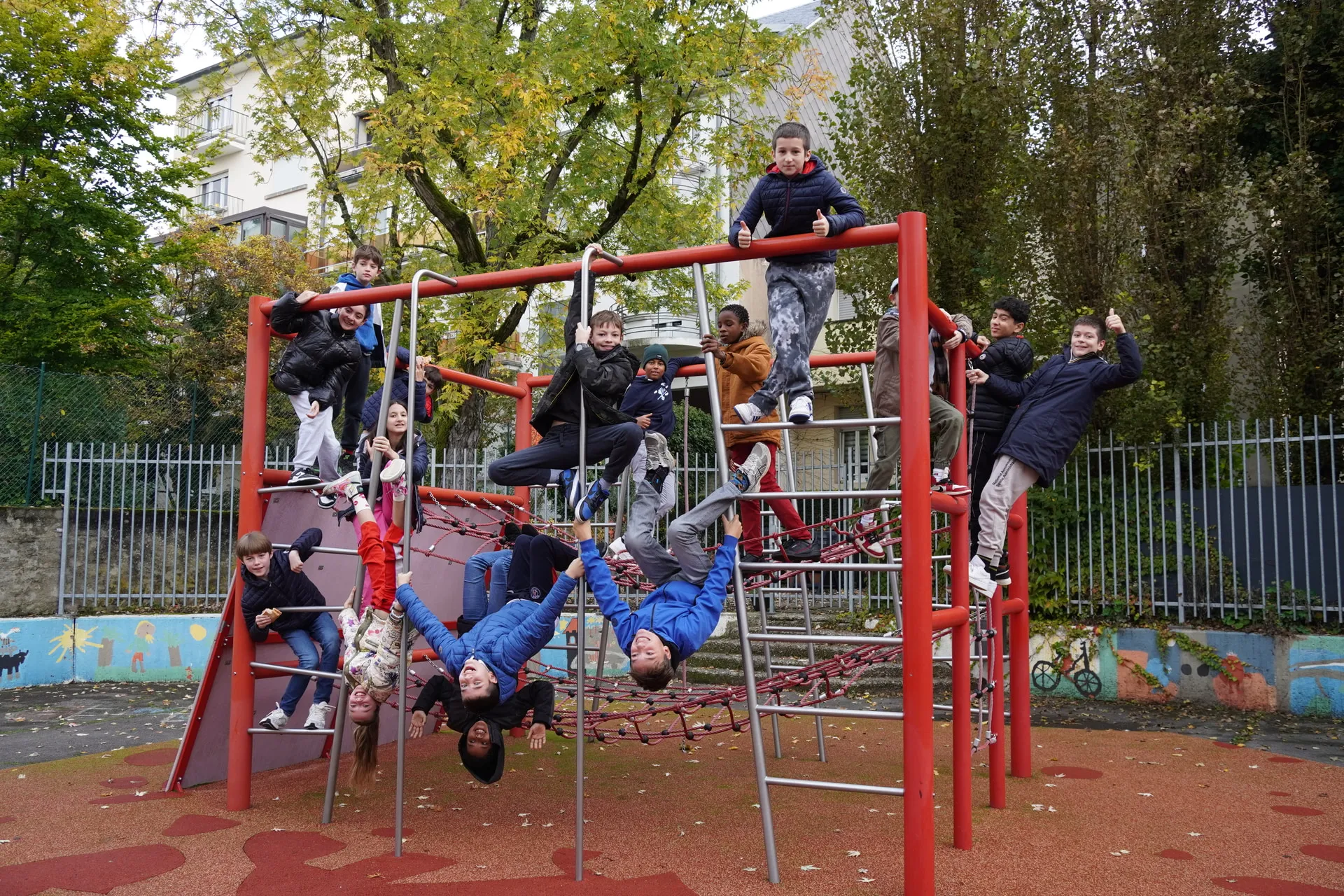 children playing on a climbing frame and posing for a photo